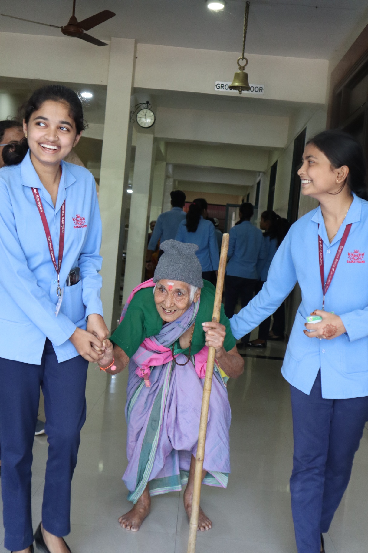 Joyful moment — students helping a smiling elder